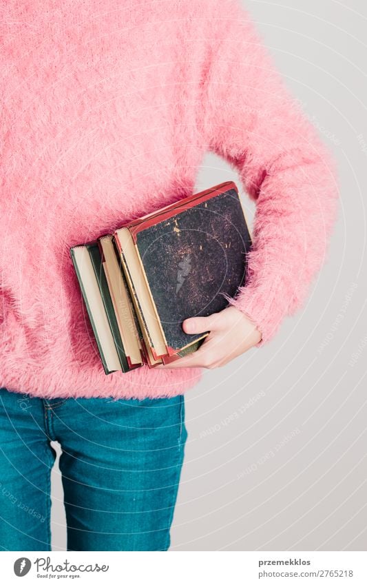 Junges Mädchen, das ein paar Bücher hält. Lifestyle Erholung Freizeit & Hobby lesen Schule lernen Mensch Frau Erwachsene Jugendliche 1 Buch Bibliothek Pullover