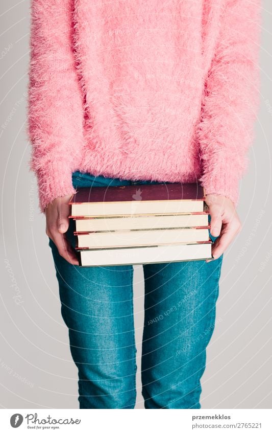 Junges Mädchen, das ein paar Bücher hält. Lifestyle Erholung Freizeit & Hobby lesen Schule lernen Mensch Frau Erwachsene Jugendliche 1 Buch Bibliothek Pullover