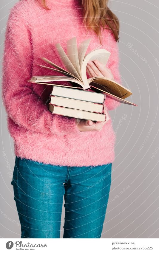 Junges Mädchen, das ein paar Bücher hält. Lifestyle Erholung Freizeit & Hobby lesen Schule lernen Mensch Frau Erwachsene Jugendliche 1 Buch Bibliothek Pullover