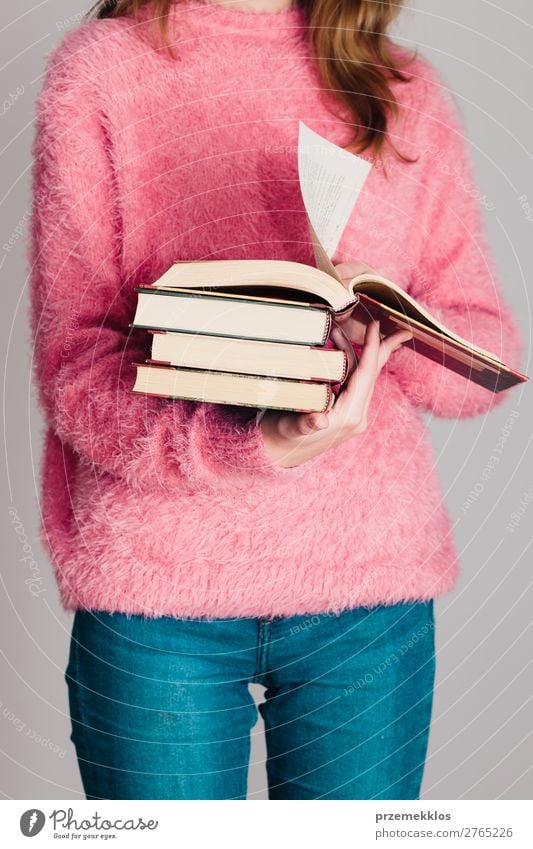 Junges Mädchen, das ein paar Bücher hält. Lifestyle Erholung Freizeit & Hobby lesen Schule lernen Mensch Frau Erwachsene Jugendliche 1 Buch Bibliothek Pullover