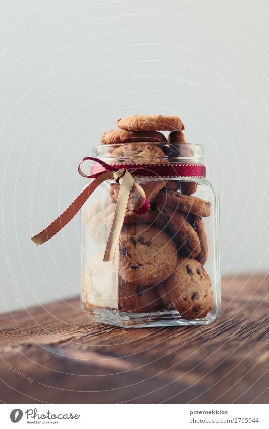 Großes Glas mit Haferplätzchen gefüllt, das auf einem Holztisch steht. Dessert Ernährung Essen Diät Lifestyle Tisch genießen lecker braun backen Bäckerei