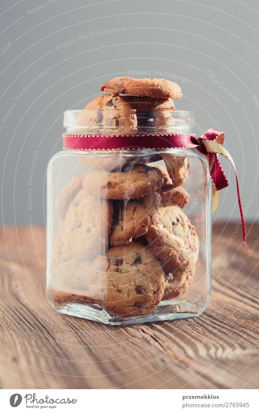 Großes Glas mit Haferplätzchen gefüllt, das auf einem Holztisch steht. Kuchen Dessert Ernährung Essen Diät Lifestyle Tisch lecker braun backen Bäckerei Biskuit