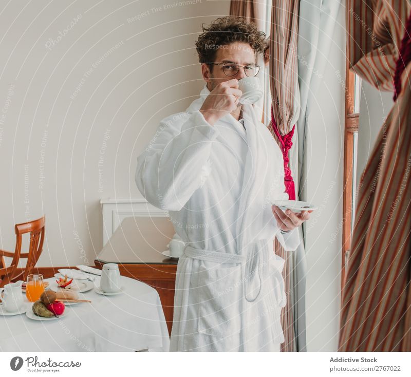 Mann im Bademantel mit Tasse selbstbewußt Stil Keramik Fenster trinken Frühstück Zimmerservice Hotel Raum Schlafzimmer heimwärts Innenarchitektur Möbel Wohnung