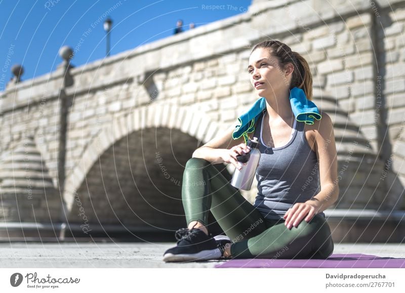 Frau ruht sich aus und trinkt Wasser mit Handtuch nach dem Training. Lifestyle schön Körper Erholung Meditation Sport Yoga Mensch Erwachsene Natur Wärme Park