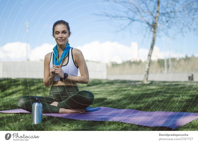 Frau ruht sich aus und trinkt Wasser mit Handtuch nach dem Training. Lifestyle schön Körper Erholung Meditation Sport Yoga Mensch Erwachsene Natur Wärme Park