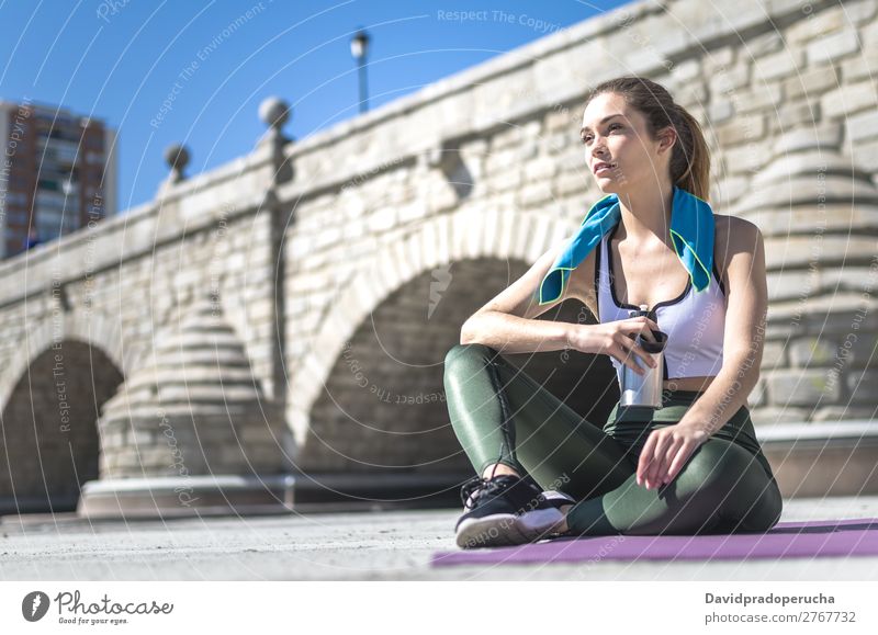 Frau ruht sich aus und trinkt Wasser mit Handtuch nach dem Training. Lifestyle schön Körper Erholung Meditation Sport Yoga Mensch Erwachsene Natur Wärme Park