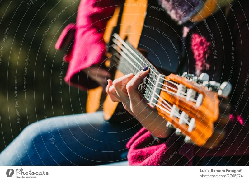 Frau, die im Freien Gitarre spielt. Lebensstil. Lifestyle Freude Glück Erholung Freizeit & Hobby Ferien & Urlaub & Reisen Winter Musik Mensch feminin Erwachsene