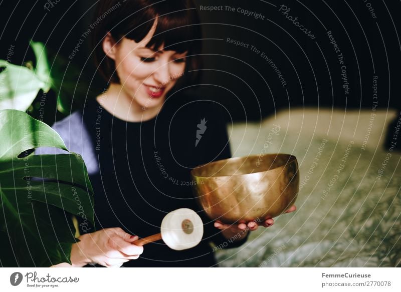 Mindfulness - Woman with singing bowl in her cozy home feminin Frau Erwachsene 1 Mensch 18-30 Jahre Jugendliche 30-45 Jahre Zufriedenheit Erholung Gelassenheit