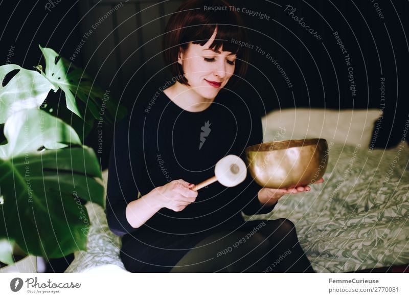 Mindfulness - Woman with singing bowl in her cozy home Lifestyle feminin Frau Erwachsene 1 Mensch 18-30 Jahre Jugendliche 30-45 Jahre Zufriedenheit Erholung