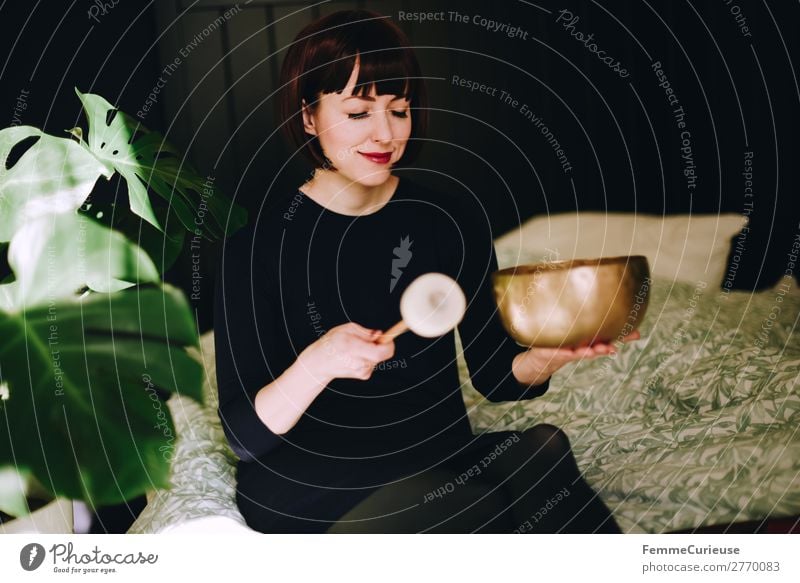 Mindfulness - Woman with singing bowl in her cozy home Gesundheit harmonisch Wohlgefühl Zufriedenheit Sinnesorgane Erholung ruhig Meditation feminin Frau