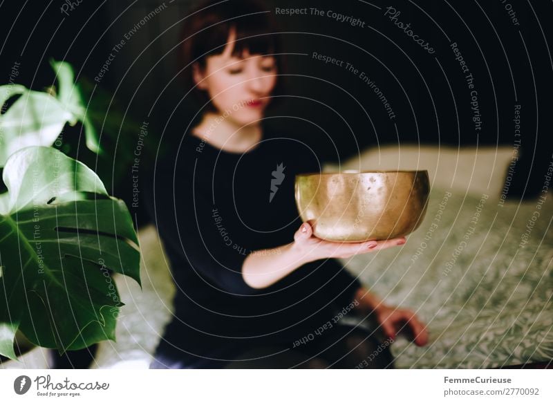 Mindfulness - Woman with singing bowl in her cozy home Gesundheit harmonisch Wohlgefühl Zufriedenheit Sinnesorgane Erholung ruhig Meditation feminin Frau