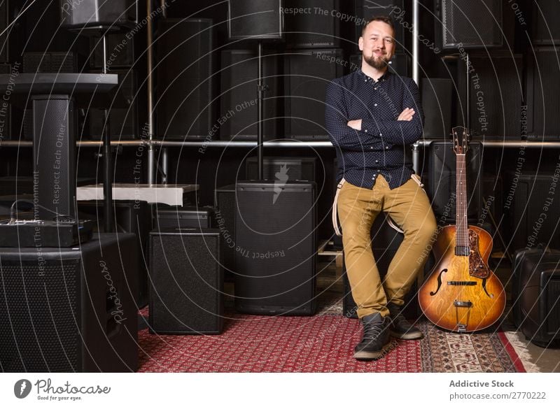 Gitarrist auf Gitarrencombo sitzend Mann kaufen Blick in die Kamera Gitarrenkombination Verkäufer Kunde Reihen Musical akustisch Gerät Mensch Business Porträt