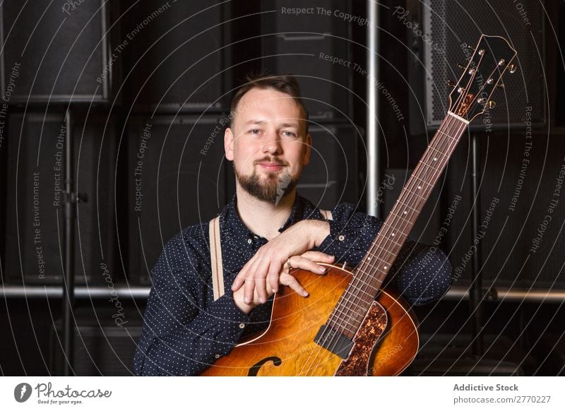 Gitarrist auf Gitarrencombo sitzend Mann kaufen Blick in die Kamera Gitarrenkombination Verkäufer Kunde Reihen Musical akustisch Gerät Mensch Business Porträt