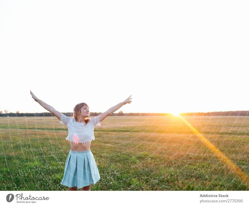 Frau, die im Feld posiert. Freiheit Sonnenuntergang romantisch Körperhaltung Natur träumen Landschaft Energie Stil Hände auseinander Erholung genießen