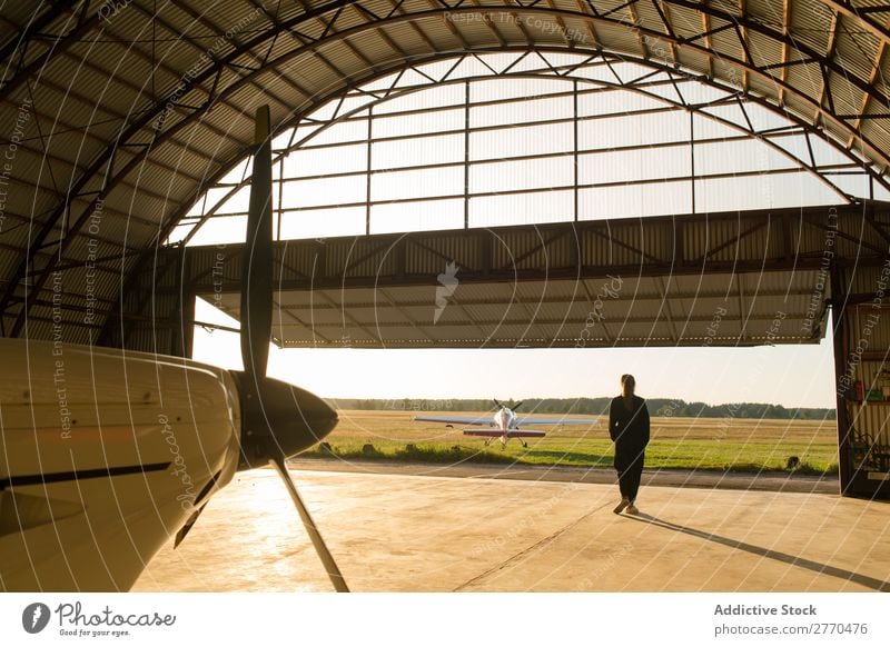 Frau, die im Hangar posiert. Körperhaltung Luftverkehr Beruf Ferien & Urlaub & Reisen heiter Freiheit Verkehr Jugendliche Abenteuer Landschaft Freizeit & Hobby