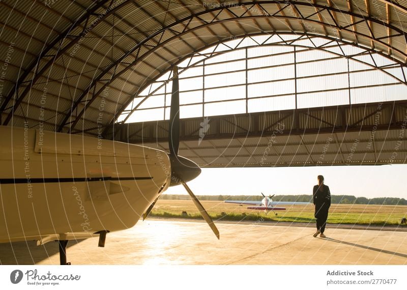 Frau, die im Hangar posiert. Körperhaltung Luftverkehr Beruf Ferien & Urlaub & Reisen heiter Freiheit Verkehr Jugendliche Abenteuer Landschaft Freizeit & Hobby