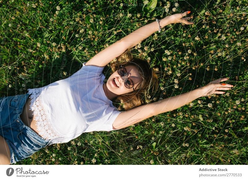 Selbstbewusstes Mädchen, das auf der grünen Wiese posiert. Frau Feld lügen heiter Körperhaltung Fröhlichkeit lässig Freiheit Natur Sommer Landschaft romantisch