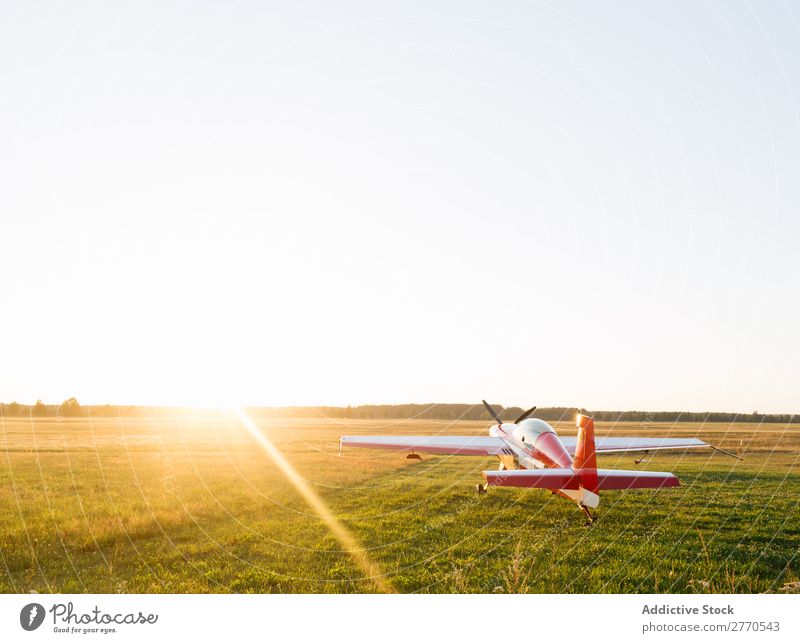 Leuchtend rotes Flugzeug im grünen Feld Flugplatz Sommer Verkehr Ferien & Urlaub & Reisen Etage Sonnenlicht Tourismus Ausflug glänzend Technik & Technologie