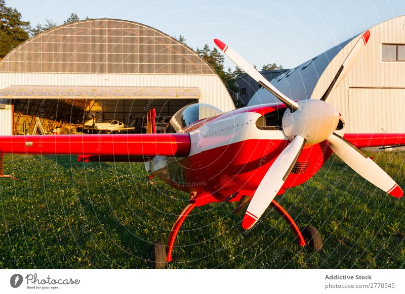 Leuchtend rotes Flugzeug im grünen Feld Flugplatz Sommer Verkehr Ferien & Urlaub & Reisen Etage Sonnenlicht Tourismus Ausflug glänzend Technik & Technologie