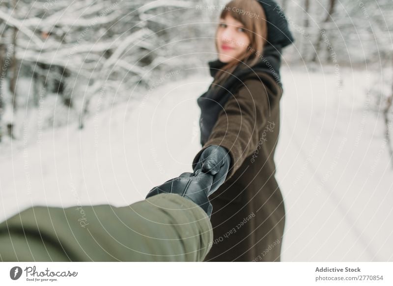 Eine gestikulierende Frau folgt mir im Winterwald. Wald Schnee kalt Natur Jugendliche mir folgen Fotograf Händchenhalten weiß schön Glück Jahreszeiten Freude