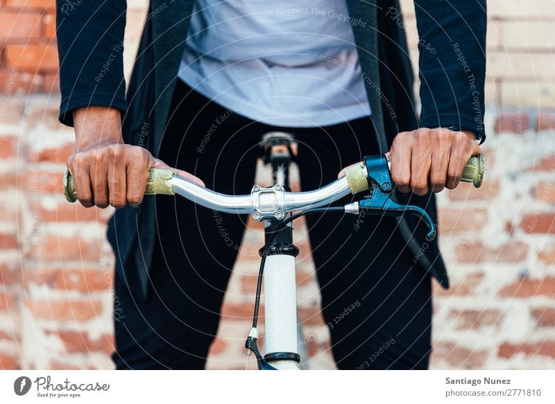 Gutaussehender Afro-Mann auf einem Fahrrad. Jugendliche Afro-Look schwarz Mulatte Afrikanisch Fahrradlenker Hand Fixie Schickimicki Lifestyle Fahrradfahren