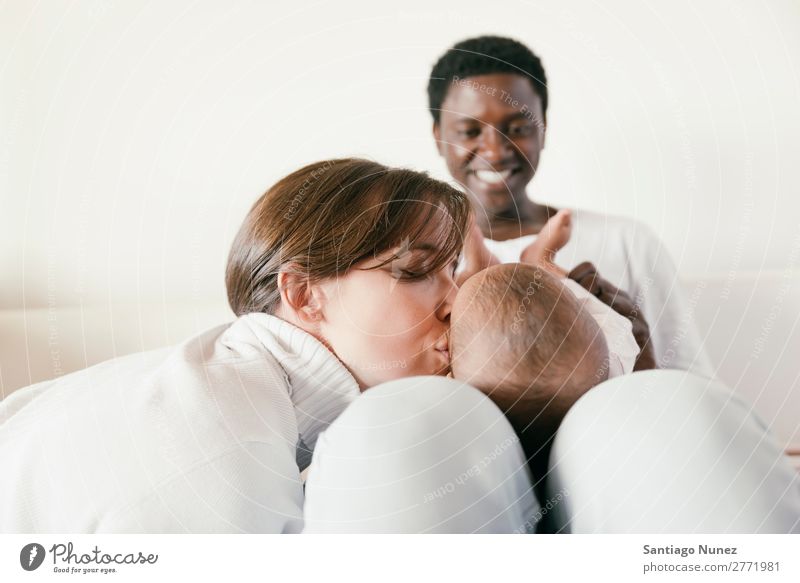 Glückliche Familie, Mutter, Vater und Baby. Junge Kind Bett Mädchen lügen neugeboren Familie & Verwandtschaft Eltern multiethnisch Afrikanisch vielfältig Mensch