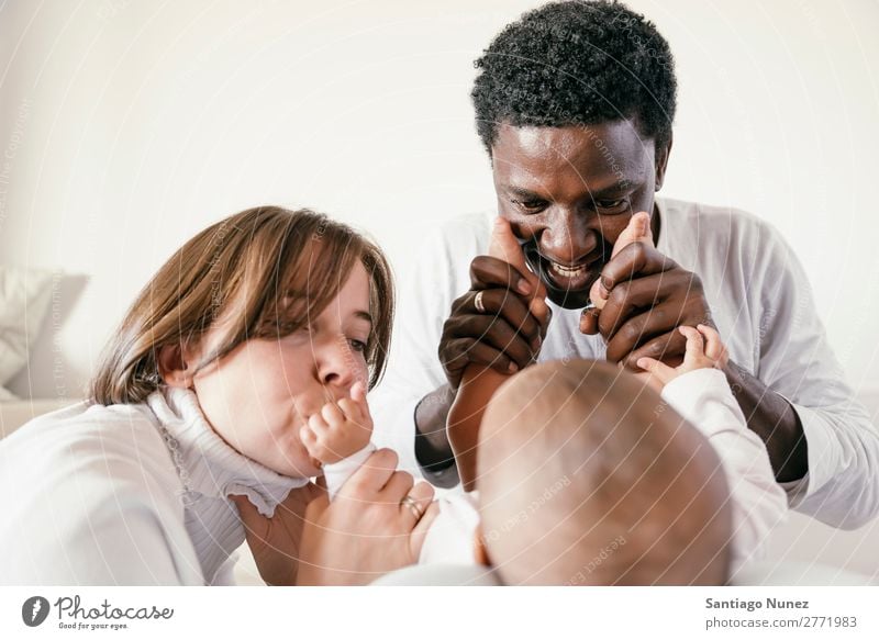 Glückliche Familie, Mutter, Vater und Baby. Junge Kind Bett Mädchen lügen neugeboren Eltern Familie & Verwandtschaft multiethnisch Afrikanisch vielfältig Mensch