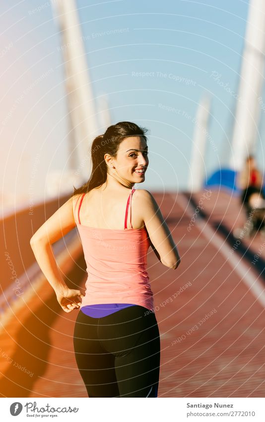 Junge Fitness-Läuferin, die auf der Stadtbrücke läuft. rennen Aktion Athlet sportlich Eisenbahn Frau Training üben Sport stark Körper anstrengen Lichtschein