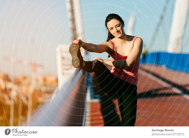 Junge Fitnesstrainerin Läuferin, die die Beine nach dem Lauf streckt. rennen Aktion Athlet sportlich Eisenbahn Frau Training üben Sport Dehnung strecken Handy