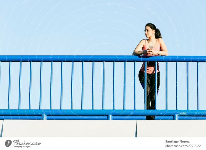 Junge Fitness-Läuferin, die auf der Stadtbrücke läuft. rennen Aktion Athlet sportlich Eisenbahn Frau Training üben Sport stark Körper anstrengen Mobile Telefon