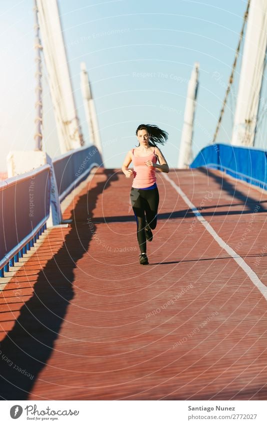 Junge Fitness-Läuferin, die auf der Stadtbrücke läuft. rennen Aktion Athlet sportlich Eisenbahn Frau Training üben Sport stark Körper anstrengen Lichtschein