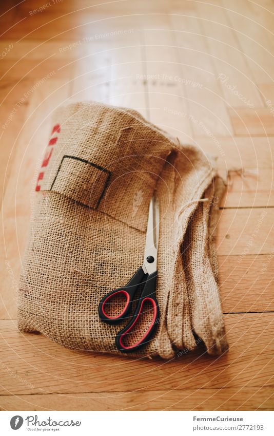 Upcycling - making garments from coffee sack Lifestyle nachhaltig Kaffeesack Schere zuschneiden Schneidern Nähen Dielenboden Farbfoto Innenaufnahme