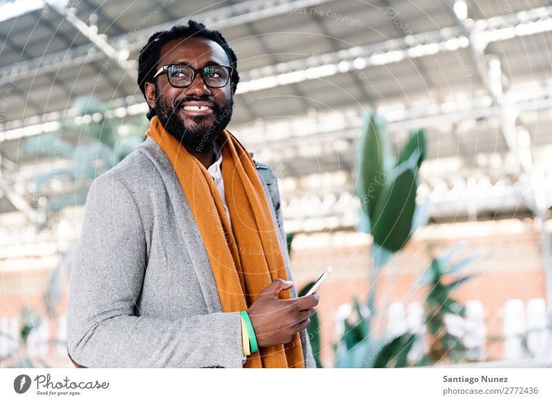 Geschäftsmann im Bahnhof. Mann schwarz Afrikanisch Amerikaner Business Handy Jugendliche Telefon Glück Mobile Innenaufnahme Straße PDA Büro Mensch