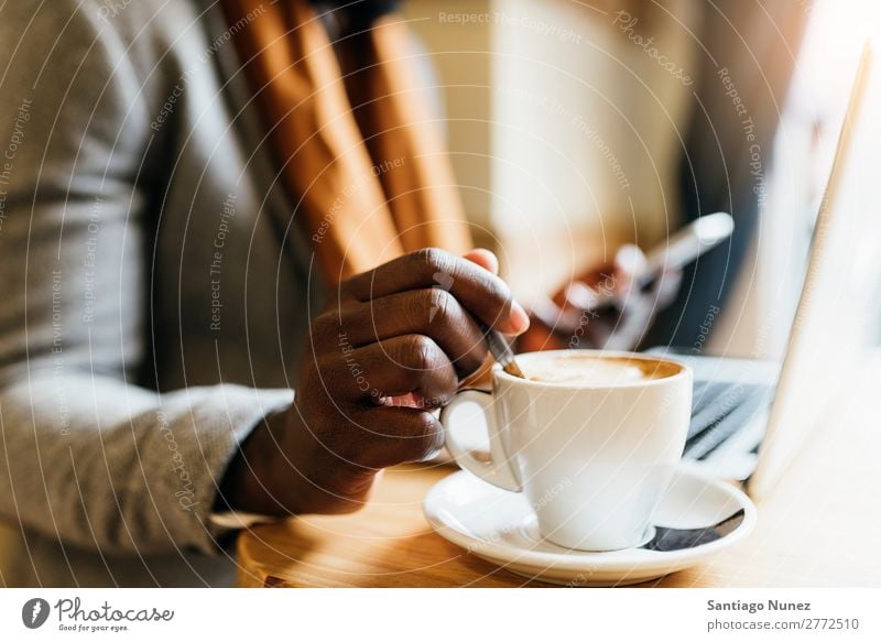 Geschäftsmann mit seinem Laptop im Coffee Shop. Mann schwarz Afrikanisch Amerikaner Business Handy Jugendliche Notebook Computer Café Kaffee Büro Mensch