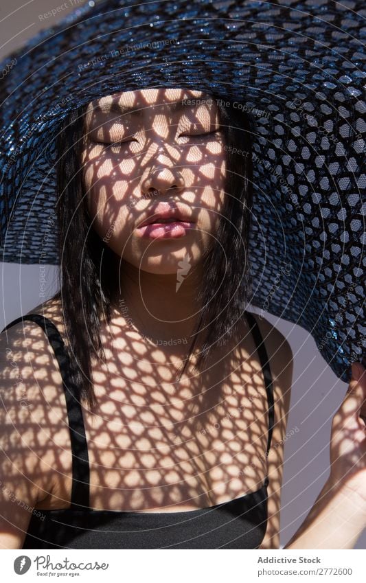 Asiatin mit großem Hut Frau Stil modisch asiatisch Sonne Schutz Schatten Raster schön Mode Beautyfotografie Jugendliche Model Porträt attraktiv elegant Glamour