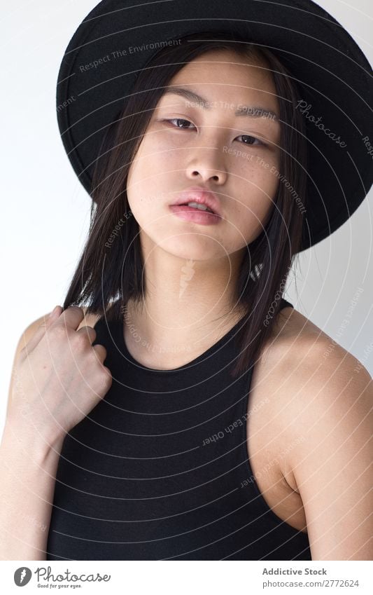 Junge asiatische Frau mit Posing im Studio mit Hut Stil modisch schön Mode Beautyfotografie Jugendliche Model Porträt attraktiv elegant Glamour hübsch Dame