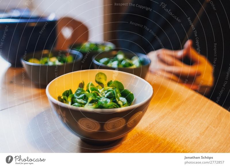 Feldsalat in einer Schüssel auf dem Tisch beim Tischgebet Lebensmittel Ernährung Zufriedenheit Lebensfreude Gesunde Ernährung Essen zubereiten Küchentisch