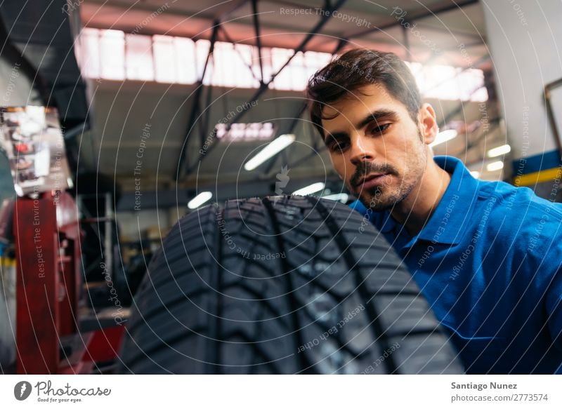 Professioneller Automechaniker bei der Arbeit. Erwachsene Mann blau Reparatur Flugzeugwartung PKW Fahrzeug Werkzeug Rad Motor Lokomotive Besichtigung heiter