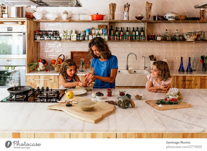 Kleine Schwestern kochen mit ihrer Mutter in der Küche. Kind Mädchen kochen & garen Koch Schokolade Speiseeis Tochter Tag Glück Freude Familie & Verwandtschaft