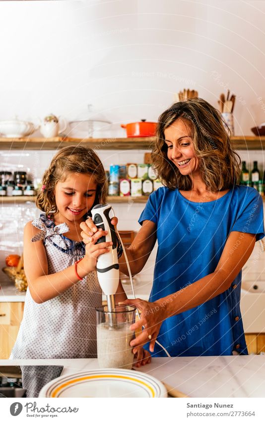 Kleines Mädchen kocht mit ihrer Mutter in der Küche. kochen & garen Koch Schokolade Speiseeis Tochter Tag Glück Freude Familie & Verwandtschaft Liebe backen