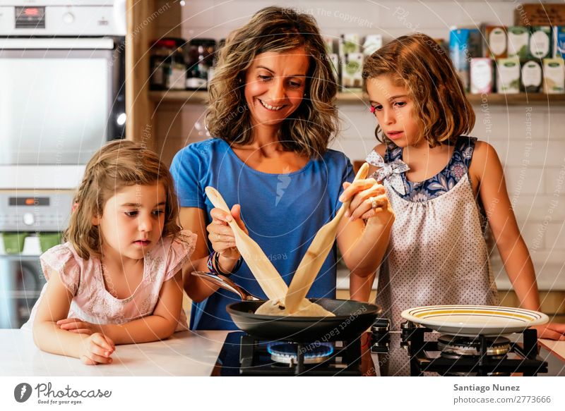 Kleine Schwestern kochen mit ihrer Mutter in der Küche. Kind Mädchen kochen & garen Koch Schokolade Speiseeis Tochter Tag Glück Freude Familie & Verwandtschaft