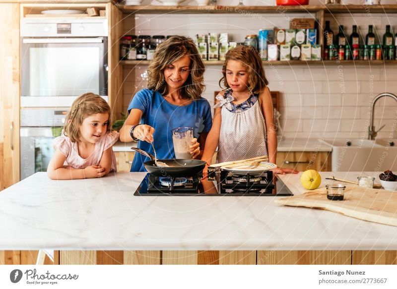 Kleine Schwestern kochen mit ihrer Mutter in der Küche. Kind Mädchen kochen & garen Koch Schokolade Speiseeis Tochter Tag Glück Freude Familie & Verwandtschaft