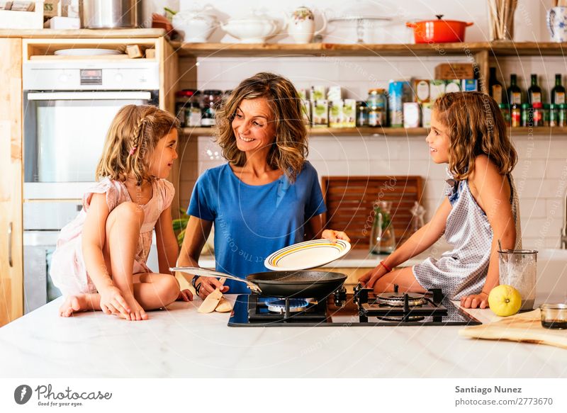 Kleine Schwestern kochen mit ihrer Mutter in der Küche. Kind Mädchen kochen & garen Koch Schokolade Speiseeis Tochter Tag Glück Freude Familie & Verwandtschaft