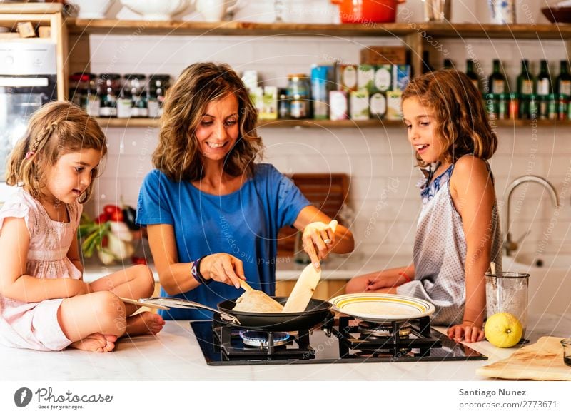 Kleine Schwestern kochen mit ihrer Mutter in der Küche. Kind Mädchen kochen & garen Koch Schokolade Speiseeis Tochter Tag Glück Freude Familie & Verwandtschaft