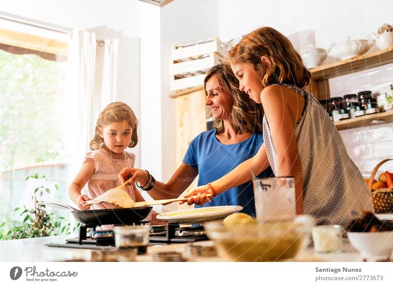 Kleine Schwestern kochen mit ihrer Mutter in der Küche. Kind Mädchen kochen & garen Koch Schokolade Speiseeis Tochter Tag Glück Freude Familie & Verwandtschaft