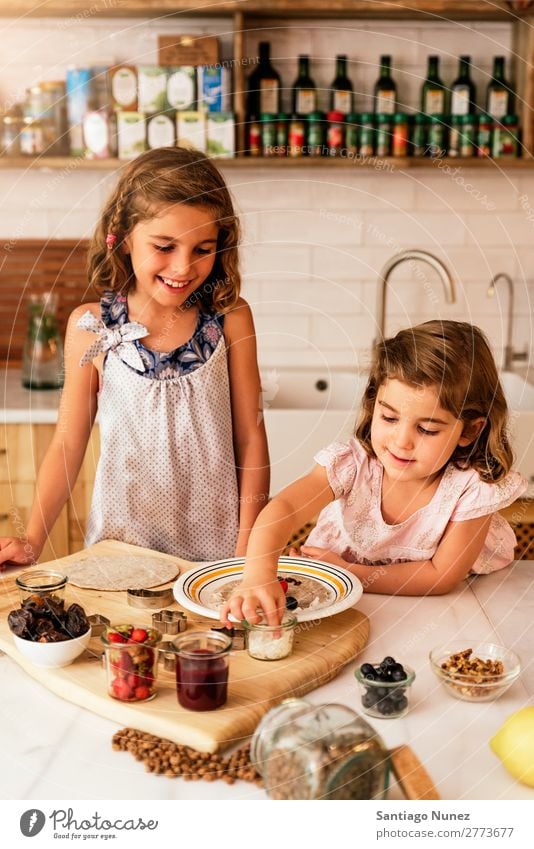 Kleine Schwestern Mädchen bereitet das Backen von Keksen vor. Kind kochen & garen Koch Küche Schokolade Speiseeis Erdbeeren Tochter Tag Glück Freude