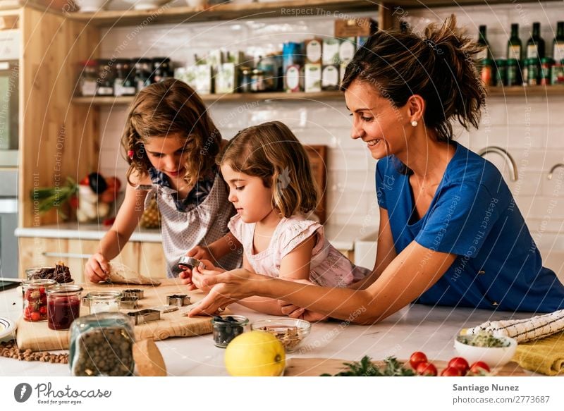 Kleine Schwestern kochen mit ihrer Mutter in der Küche. Kind Mädchen kochen & garen Koch Schokolade Speiseeis Tochter Tag Glück Freude Familie & Verwandtschaft