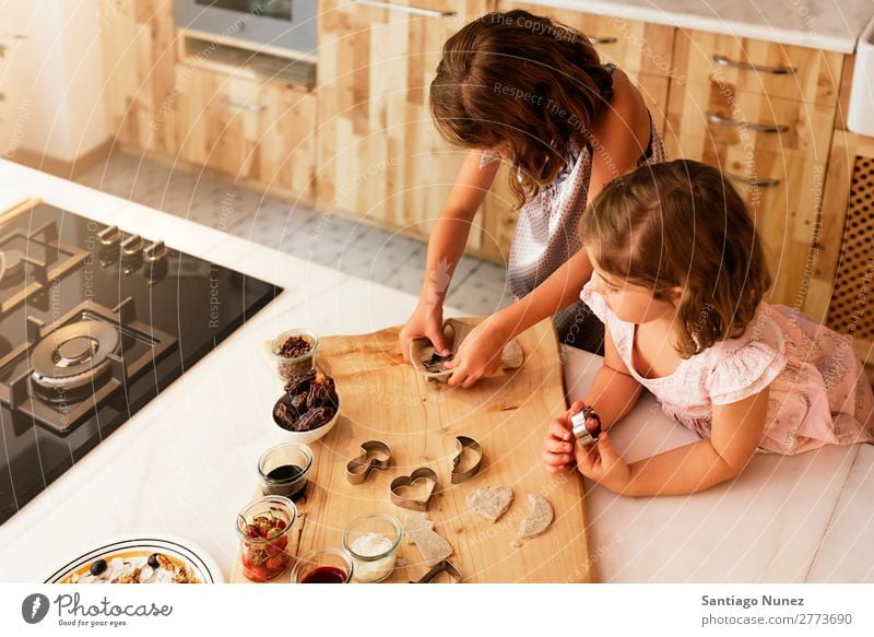 Kleine Schwestern Mädchen bereitet das Backen von Keksen vor. Kind kochen & garen Koch Küche Schokolade Speiseeis Erdbeeren Tochter Tag Glück Freude