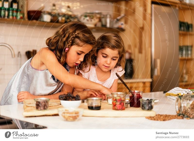 Kleine Schwestern Mädchen bereitet das Backen von Keksen vor. Kind kochen & garen Koch Küche Schokolade Speiseeis Erdbeeren Tochter Tag Glück Freude