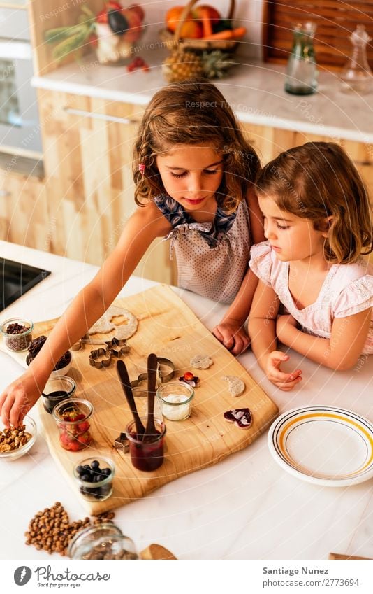 Kleine Schwestern Mädchen bereitet das Backen von Keksen vor. Kind kochen & garen Koch Küche Schokolade Speiseeis Erdbeeren Tochter Tag Glück Freude